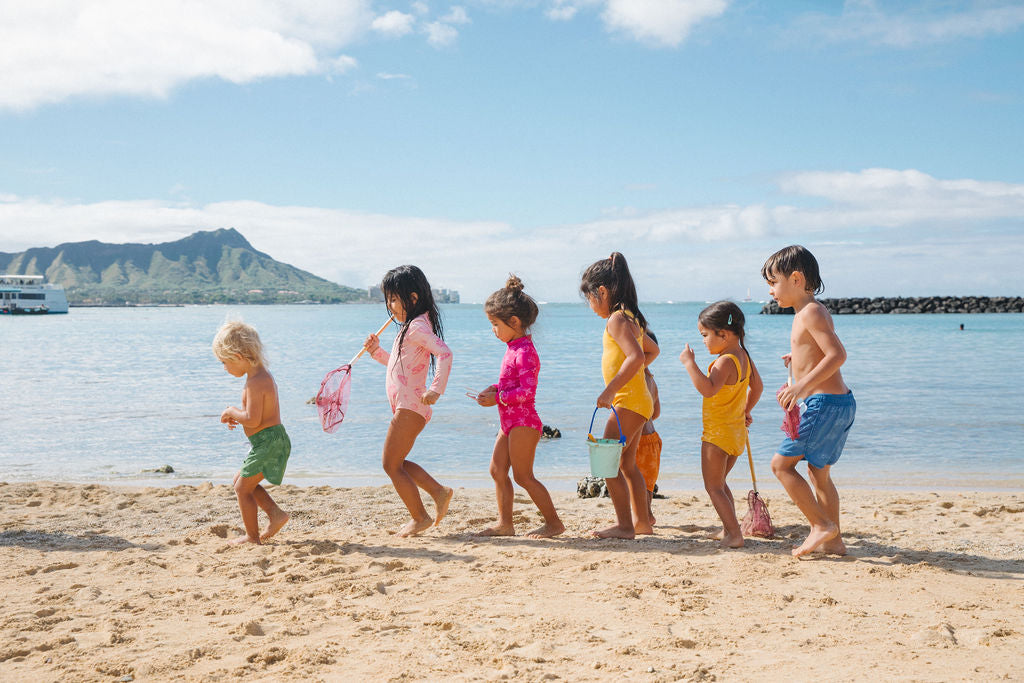 Children walking in a line and playing on the beach